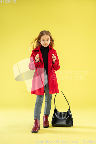 Image of A full length portrait of a bright fashionable girl in a raincoat