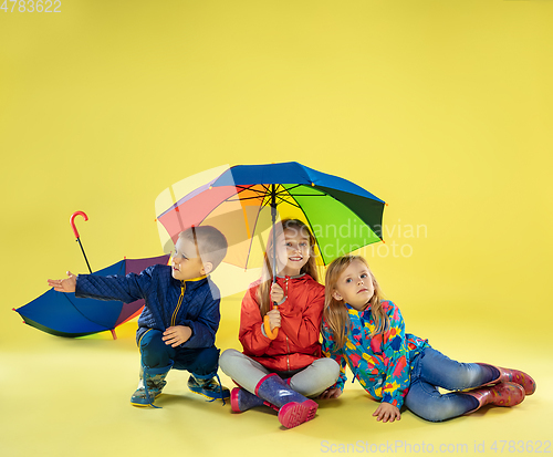 Image of A full length portrait of a bright fashionable kids in a raincoat