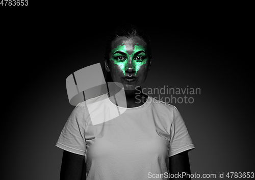 Image of Close up portrait of young woman isolated on black studio background