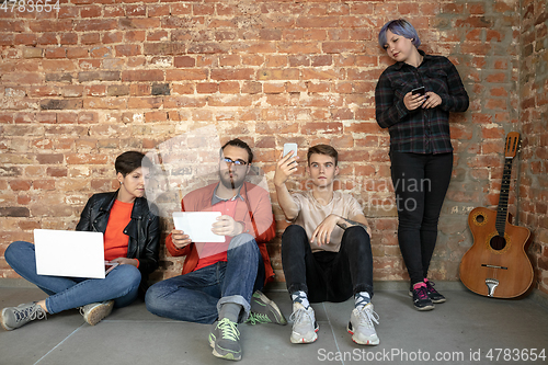 Image of Group of happy young men and women sharing in social media