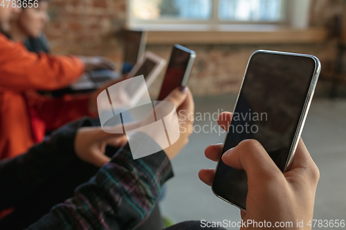 Image of Close up hands of group of happy young people sharing in social media