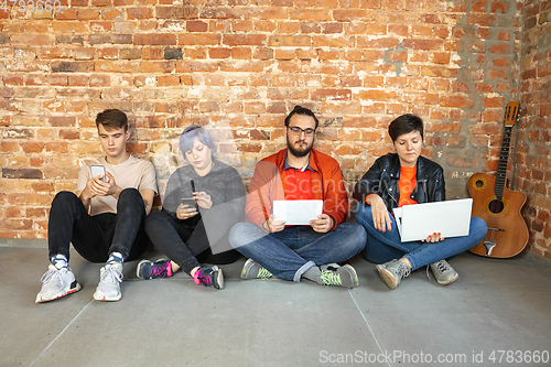 Image of Group of happy young men and women sharing in social media