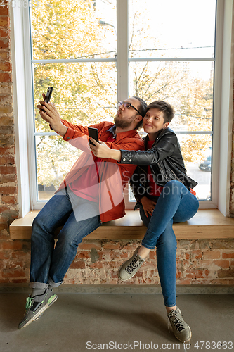 Image of Happy young man and woman sharing in social media