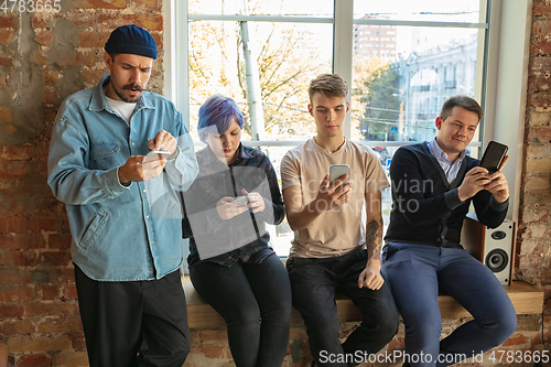 Image of Group of happy young men and women sharing in social media