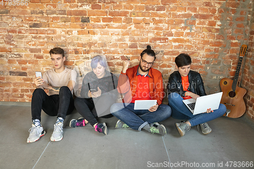Image of Group of happy young men and women sharing in social media