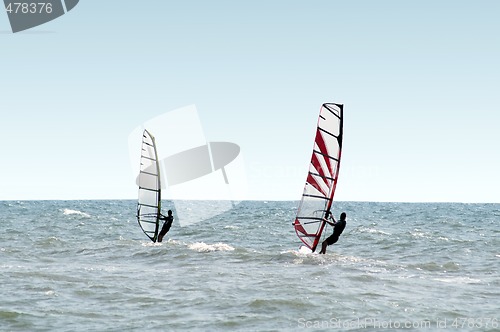 Image of Two windsurfers on waves of a sea 