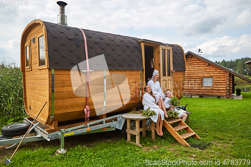 Image of three girls relaxing outside sauna