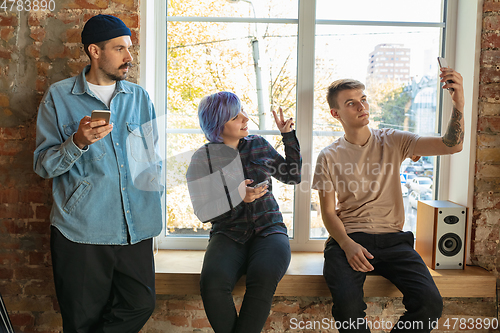 Image of Group of happy young men and women sharing in social media