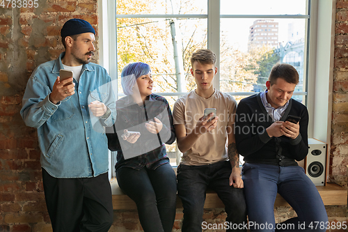 Image of Group of happy young men and women sharing in social media