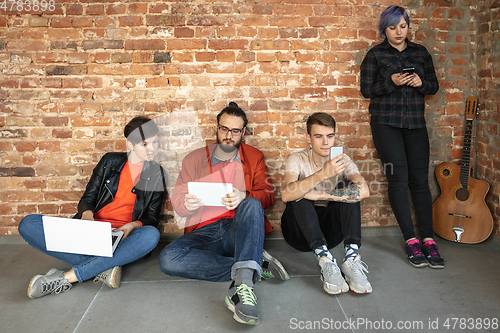 Image of Group of happy young men and women sharing in social media