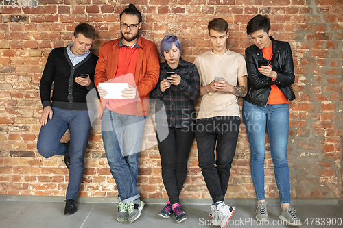 Image of Group of happy young men and women sharing in social media