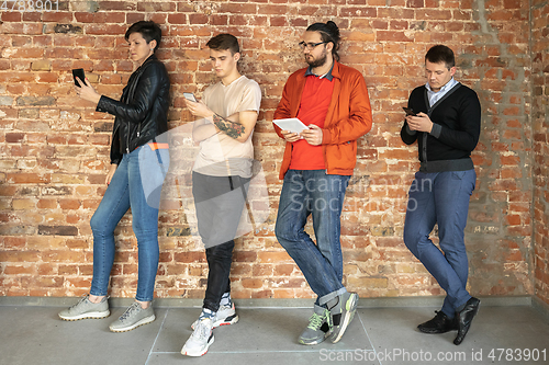 Image of Group of happy young men and women sharing in social media