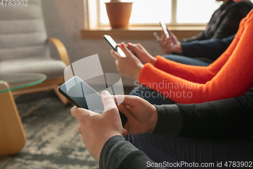 Image of Close up hands of group of happy young people sharing in social media