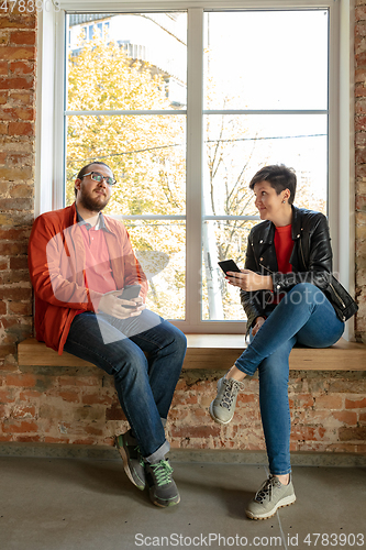 Image of Happy young man and woman sharing in social media