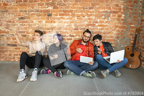 Image of Group of happy young men and women sharing in social media