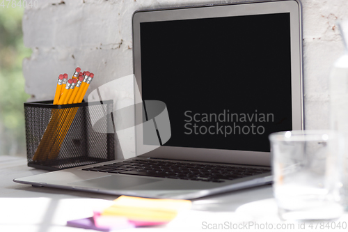 Image of Mock up empty black laptop screen on white brick wall background