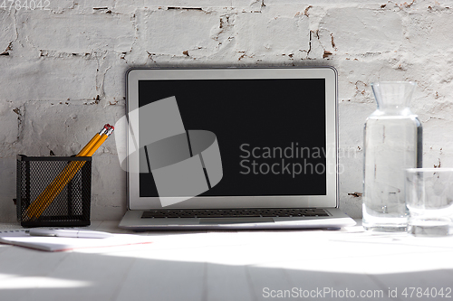 Image of Mock up empty black laptop screen on white brick wall background