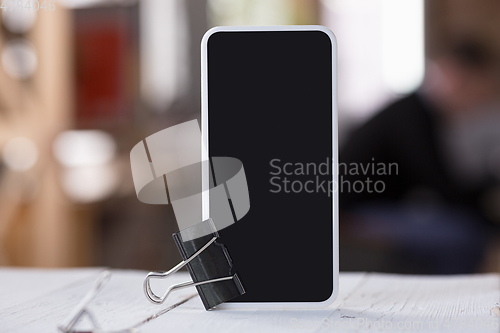 Image of Mock up empty black smartphone screen on blured background