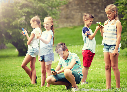 Image of kids with smartphones playing game in summer park