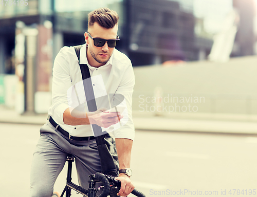 Image of man with bicycle and smartphone on city street