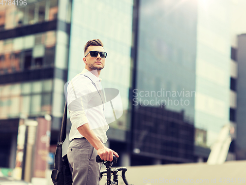 Image of young man with bicycle on city street