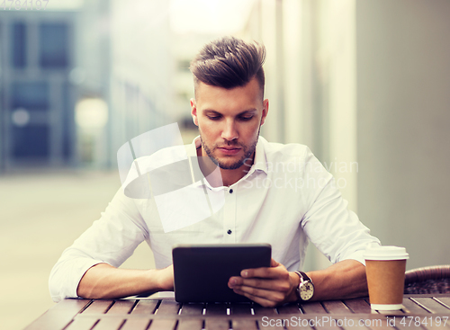 Image of man with tablet pc and coffee at city cafe