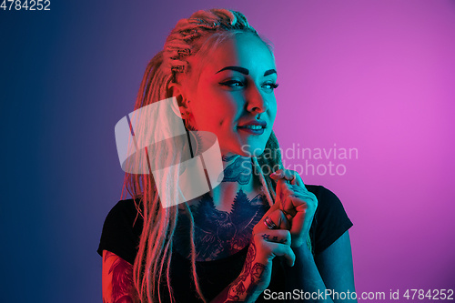 Image of Caucasian young woman\'s portrait on gradient background in neon light