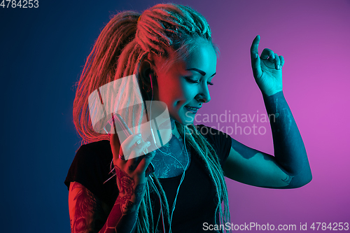 Image of Caucasian young woman\'s portrait on gradient background in neon light