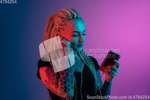 Image of Caucasian young woman\'s portrait on gradient background in neon light