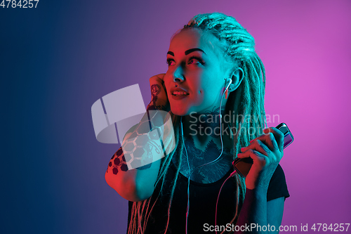 Image of Caucasian young woman\'s portrait on gradient background in neon light