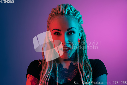 Image of Caucasian young woman\'s portrait on gradient background in neon light