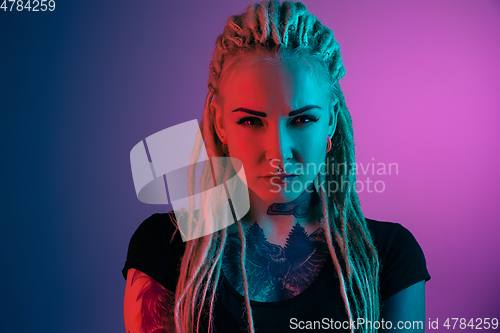 Image of Caucasian young woman\'s portrait on gradient background in neon light