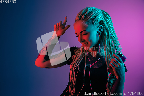 Image of Caucasian young woman\'s portrait on gradient background in neon light