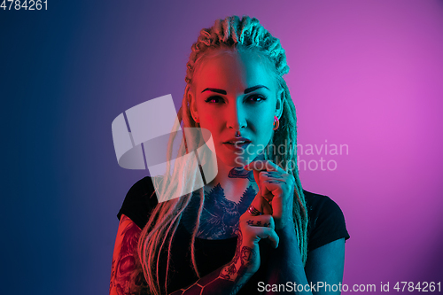 Image of Caucasian young woman\'s portrait on gradient background in neon light