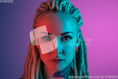 Image of Caucasian young woman\'s portrait on gradient background in neon light