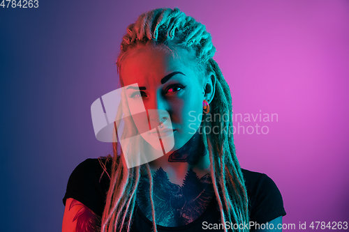 Image of Caucasian young woman\'s portrait on gradient background in neon light