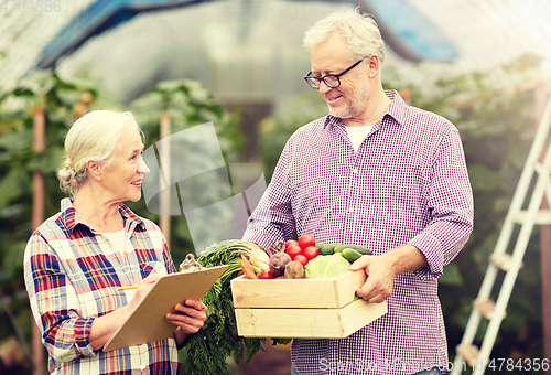 Image of senior couple with box of vegetables on farm