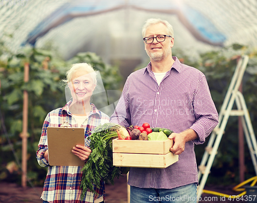 Image of senior couple with box of vegetables on farm