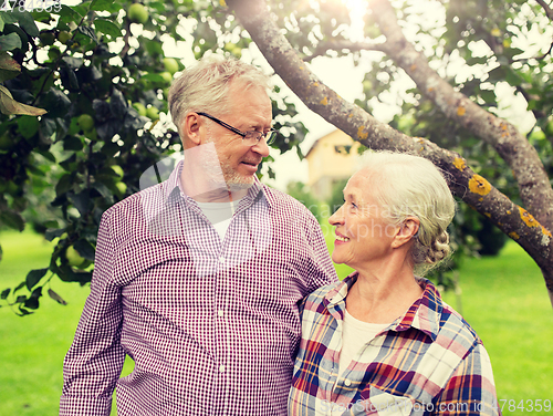 Image of happy senior couple hugging at summer garden