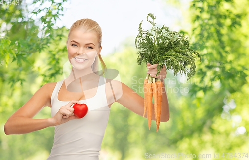 Image of happy smiling young woman with heart and carrots