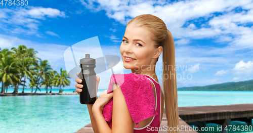 Image of happy smiling woman with sports bottle and towel