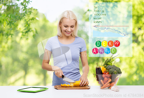 Image of smiling young woman cooking vegetables