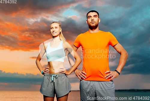 Image of happy couple exercising over sea