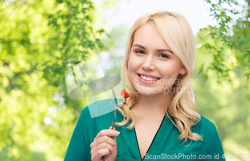 Image of smiling young woman eating vegetables with fork