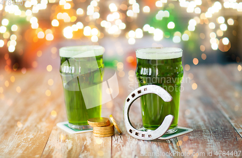 Image of glasses of green beer, horseshoe and gold coins