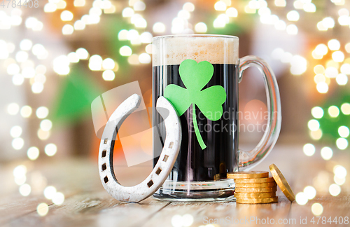 Image of shamrock on glass of beer, horseshoe and coins