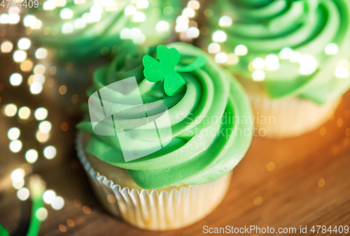 Image of green cupcakes and shamrock on wooden table