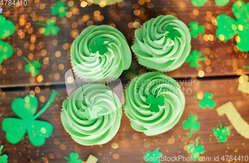 Image of green cupcakes and shamrock on wooden table