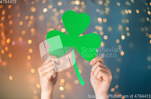 Image of hands holding green paper shamrock