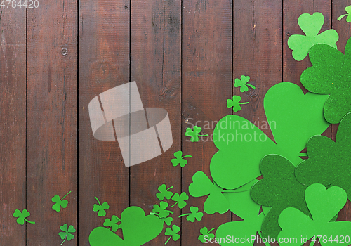 Image of green paper shamrocks on wooden background